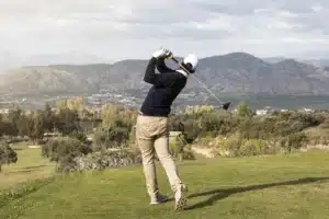 A golfer at the end of their swing
