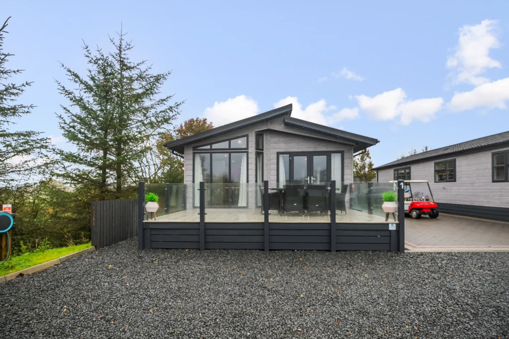 Exterior of a lodge at Arranview with decking and parking